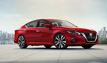 2023 Nissan Altima in red with city in background illustrating last year's 2022 model in Winners Circle Nissan in Hampton VA