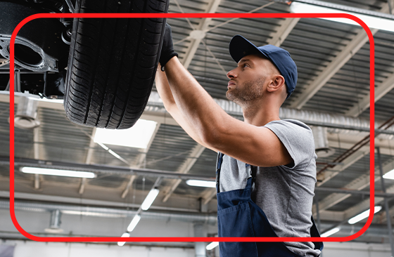  Learn Maintenance Warning Signs at Winners Circle Nissan in Hampton, VA | Mechanic with hat is inspecting car tires 